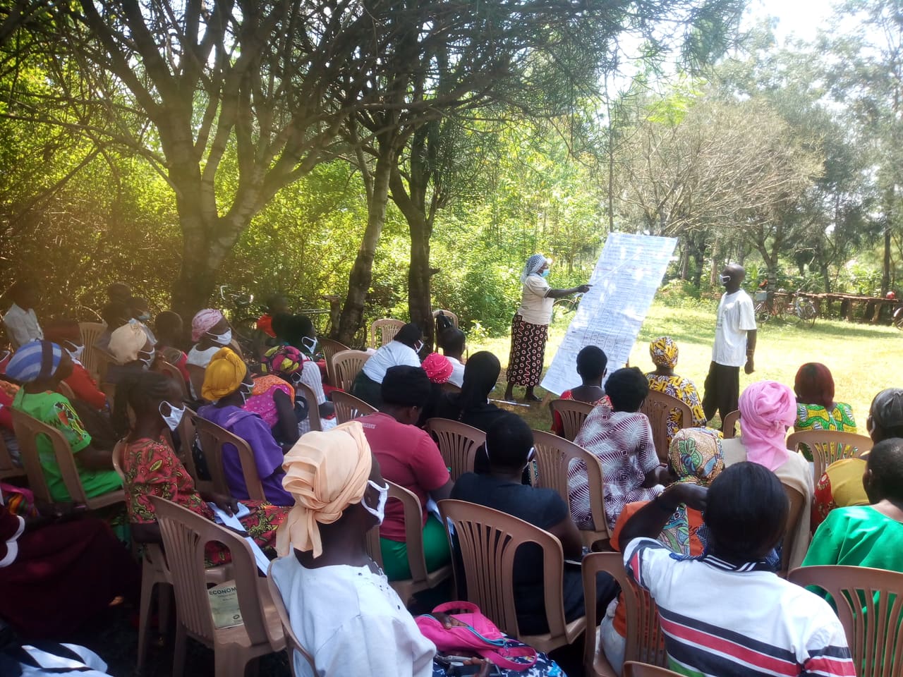 A community social protection training session led by BREFON facilitators under trees in Northern Uganda.